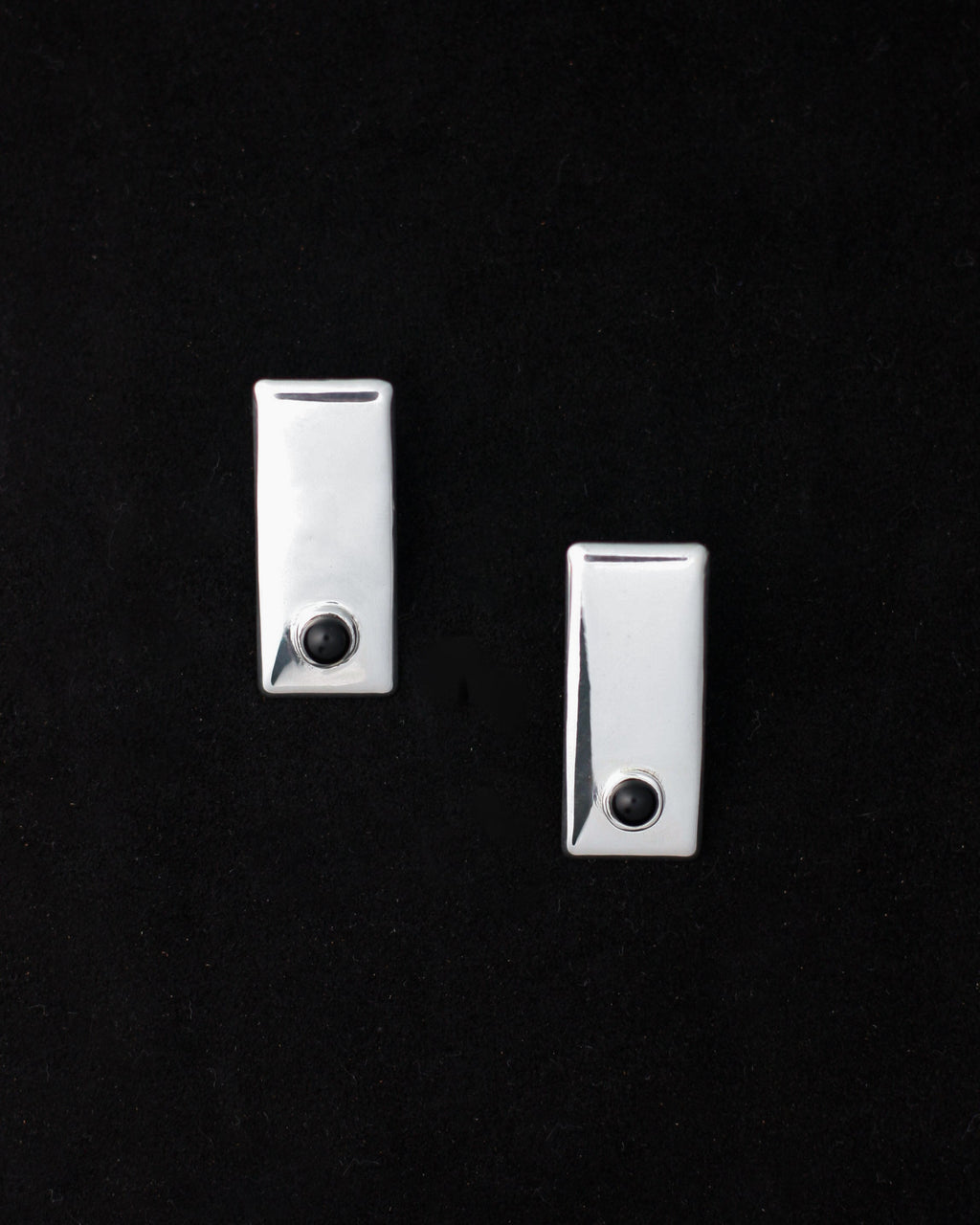 A pair of 925 sterling silver onyx earrings against a black background.